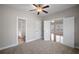 A spacious main bedroom with a ceiling fan, carpet floors, and a view into the living room at 1502 Park Hollow Ln, Lawrenceville, GA 30043