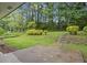Landscaped backyard features a stone patio, mature trees, and lush greenery, creating a peaceful outdoor space at 2478 Graywall St, Atlanta, GA 30344