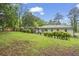 Spacious backyard with a lush green lawn, mature trees, and manicured landscaping, and a fenced perimeter at 2478 Graywall St, Atlanta, GA 30344