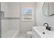 A bathroom featuring tiled shower, updated vanity, modern fixtures, and sleek lighting at 2478 Graywall St, Atlanta, GA 30344