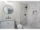 Stylish bathroom featuring a marble tiled shower, modern fixtures, and a round mirror above the vanity at 2478 Graywall St, Atlanta, GA 30344