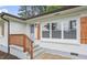 Charming home with a small porch with wood railings, white siding, light blue door, and wood shutters at 2478 Graywall St, Atlanta, GA 30344