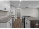 Modern kitchen featuring white cabinets, stainless steel appliances, and an island with a cooktop at 2478 Graywall St, Atlanta, GA 30344