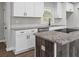 Modern kitchen featuring white cabinets, stainless steel appliances, and an island with a cooktop at 2478 Graywall St, Atlanta, GA 30344