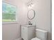 Bright bathroom with a vanity, toilet, and a window bringing in natural light at 2478 Graywall St, East Point, GA 30344