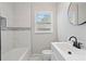 Bathroom featuring white vanity sink, a tub, and decorative tiles at 2478 Graywall St, East Point, GA 30344