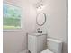 Bathroom with a white vanity sink and a circular mirror at 2478 Graywall St, East Point, GA 30344