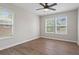A modern bedroom with hardwood style floors, ceiling fan, and three windows at 2478 Graywall St, East Point, GA 30344