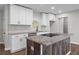 Close up of updated kitchen with white cabinets, gray countertop, stainless steel appliances, and rustic island at 2478 Graywall St, East Point, GA 30344