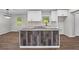 Kitchen island with grey granite countertop and wood-look accent panels and modern appliances at 2478 Graywall St, East Point, GA 30344