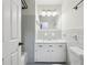 Bathroom features a white vanity, neutral tile, and a shower-tub combination with white painted door at 767 Smithstone Se Rd, Marietta, GA 30067