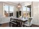 Dining room featuring dark wood floors, large windows, a modern chandelier, and seating for six at 821 Bufflehead Ct, Stockbridge, GA 30281