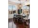 Dining room featuring dark wood floors, large windows, a modern chandelier, and seating for six at 821 Bufflehead Ct, Stockbridge, GA 30281