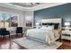 Beautiful main bedroom with tray ceiling, hardwood floors, and sitting area by the window at 821 Bufflehead Ct, Stockbridge, GA 30281