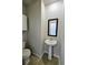 Modern powder room with pedestal sink, dark framed mirror and wood look flooring at 2510 Polaris Sw Way, Atlanta, GA 30331