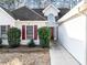 Close up of the front exterior featuring landscaped bushes, red shutters, and a two car garage at 2577 Twin Oaks Sw Dr, Marietta, GA 30064