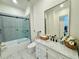 Modern bathroom with a marble vanity, black faucet, framed mirror, and a glass-enclosed tub-shower combo at 3987 St Georges Ct, Duluth, GA 30096