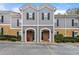 Charming townhome featuring brick accents, neutral siding, and decorative shutters on the upper windows at 204 Summer Pl, Norcross, GA 30071