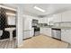 Modern kitchen with stainless steel appliances, white cabinetry, and stylish tile backsplash, plus adjacent powder room at 204 Summer Pl, Norcross, GA 30071