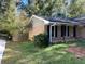 Side yard with small porch, lawn, and a mix of trees and bushes at 4045 Westview St, Douglasville, GA 30135