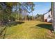 Backyard featuring a large grassy area, mature trees, and partial fencing, providing a private outdoor setting at 4100 Brown Rd, Tucker, GA 30084