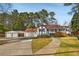 Cozy home with detached garage, a front porch, and driveway surrounded by a large lawn at 4100 Brown Rd, Tucker, GA 30084