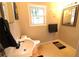 Compact bathroom featuring a white sink, toilet, and window with natural light at 810 Gettysburg Trl, Kennesaw, GA 30144