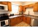 Well-lit kitchen featuring stainless steel appliances, wood cabinets and double sinks at 810 Gettysburg Trl, Kennesaw, GA 30144