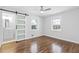 Bedroom with hardwood floors, a sliding door to an ensuite, and two bright windows at 1889 Cannon St, Decatur, GA 30032