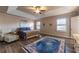 Spacious bedroom with tray ceiling, ceiling fan, wood floors, and a decorative area rug at 2075 Crabapple Parc Way, Roswell, GA 30076