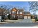Traditional brick home with a well-manicured lawn, two-car garage, and symmetrical window shutters at 2075 Crabapple Parc Way, Roswell, GA 30076