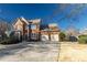 Beautiful two-story brick home with an attached two-car garage, and a well-kept lawn on a sunny day at 2075 Crabapple Parc Way, Roswell, GA 30076