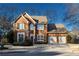 Inviting two-story brick home featuring a well-maintained lawn and a convenient two-car garage at 2075 Crabapple Parc Way, Roswell, GA 30076