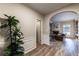 View of the hall that connects to a living room, features include hardwood floors, white wall trim, and a large green plant at 2075 Crabapple Parc Way, Roswell, GA 30076