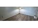 Image of an empty room with hardwood floors and a white plant in the corner, featuring a lamp in the corner of the room at 2075 Crabapple Parc Way, Roswell, GA 30076