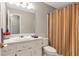 Cozy bathroom with vanity, toilet, and shower with striped curtain at 239 Taylors Farm Dr, Canton, GA 30115