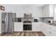 Bright kitchen with stainless steel appliances, white cabinets and hardwood floors at 239 Taylors Farm Dr, Canton, GA 30115