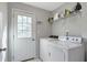Functional laundry room with washer, dryer, and storage shelving at 239 Taylors Farm Dr, Canton, GA 30115