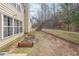 Backyard with wooden retaining wall, garden bed, and lawn at 349 Azalea Chase Dr, Suwanee, GA 30024