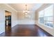 Bright dining room features hardwood floors, large window, wainscoting and chandelier at 349 Azalea Chase Dr, Suwanee, GA 30024