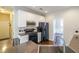 View of kitchen with white cabinets and black appliances, offering a view into a separate dining space at 349 Azalea Chase Dr, Suwanee, GA 30024