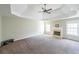 Spacious primary bedroom with a fireplace, tray ceiling, ceiling fan, and large windows at 349 Azalea Chase Dr, Suwanee, GA 30024