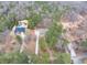 An aerial view captures the home's placement within a heavily wooded lot, near another home and pool at 2935 Pruitt Rd, Cumming, GA 30041