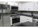 Modern kitchen equipped with stainless steel appliances, sleek black countertops, and white cabinets at 6658 Collins Ct, Riverdale, GA 30274
