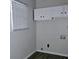 Functional laundry room features overhead storage cabinets, window, and new hardwood floors at 6658 Collins Ct, Riverdale, GA 30274