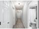 Neutral hallway featuring carpet flooring, white doors, and a bathroom visible at the end at 2540 River Summit Dr, Duluth, GA 30097