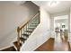 Staircase with wood railing and decorative wrought iron spindles with views into the kitchen at 2540 River Summit Dr, Duluth, GA 30097