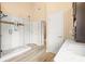 Well-lit bathroom with a glass-enclosed shower, wooden floors, and convenient storage cabinets at 2915 Pruitt Rd, Cumming, GA 30041