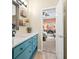 Stylish bathroom with teal vanity, stone countertop, decorative wall shelves and natural light at 2915 Pruitt Rd, Cumming, GA 30041