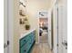 Stylish bathroom with teal vanity, stone countertop, decorative wall shelves and natural light at 2915 Pruitt Rd, Cumming, GA 30041